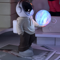 Holding a dreamy starry sky (beige top + brown pants) Creative Astronaut Bluetooth Speaker with 3D Starry Sky Lighting, Portable Wireless Moon Lamp Sp